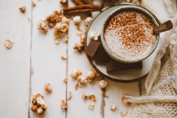 chocolat chaud dans un tasse avec pop corn autour
