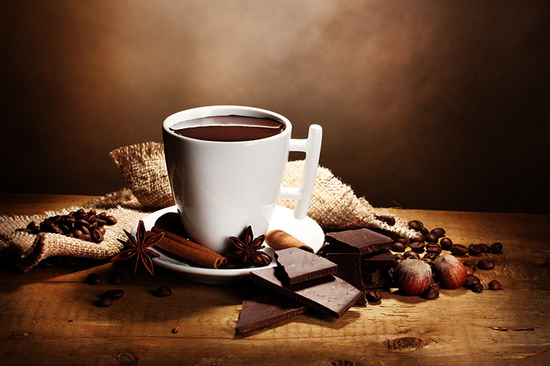tasse de chocolat chaud avec morceaux de chocolat et noisettes